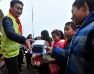 志愿者为贫困学生发放文具等新年礼物