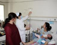 在医院感染一科记者看到，病房里、走廊里到处都是前来就诊患者，而他们中又以儿童居多。从上班开始一直到下班8个小时，护士都在忙碌着，几乎难得有片刻歇停。交接班、查房、量体温、配药、送药、打针……。（护士正给病人换着输液瓶，再三询问患者是否舒适后，才放心走出病房。）