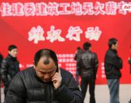 2013年1月27日，宁波市住建委“建筑工地无欠薪专项维权行动”在宁波书城外广场举行，20余家大型建筑企业负责人现场办公，对讨薪工人涉及的问题现场进行解答，确保工人及时拿到工钱，开心回家过春节。图为一位工人在打电话。张培坚/视觉中国