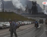 松汀村民毛温秀，今年60岁，他背着箩筐，手拿铲子去捡焦炭。他以此为生。