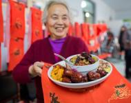 1月4日，内蒙古呼和浩特市玉泉区清泉街社区一位老人在展示腊八粥食材。当日，呼和浩特市玉泉区清泉街社区举办“温暖腊八粥 浓浓邻里情”活动，喜迎即将到来的“腊八节”。新华社发 丁根厚 摄