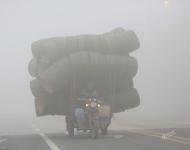 2017年1月3日，江苏连云港赣榆区，一辆三轮车满载货物在大雾中缓慢行驶。思维/视觉中国